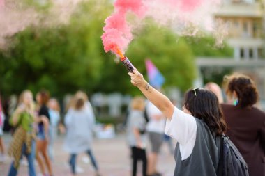 Podgorica, Karadağ - 8 Ekim 2022: On Onur Yürüyüşü sırasında elinde pembe bir duman bombası tutan aktivist kadın. Eşit haklar için savaş. Gökkuşağı bayrağı Lgbt toplumunun sembolüdür