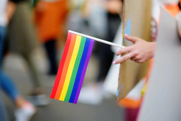 Activist holding rainbow flag and banner on the march on the city street during the Pride Parade. Fighting for equality os sexual minorities. Rainbow flag is a symbol of lgbt community