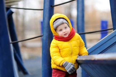 Sevimli küçük çocuk açık sahada eğleniyor. Çocuklar için Bahar, Sonbahar ya da kış etkin boş.
