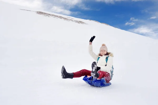 アルプスのそりで山の斜面を転がり落ちる時に楽しんで幸せな中年女性 雪と冬のスポーツ アルプスの山々 で典型的な楽しみ そりに乗っている人 — ストック写真