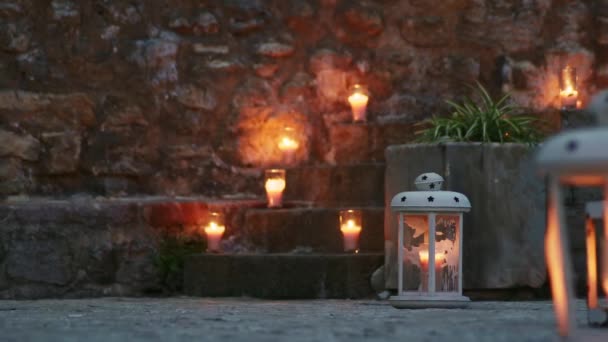 在一座欧洲古城的楼梯上燃着的蜡烛 在蓝色黄昏或黄昏时举行的婚礼或招待会 餐厅的入口装饰着燃烧的蜡烛 — 图库视频影像