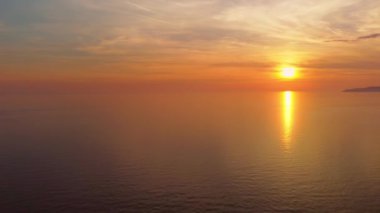 İnsansız hava aracından batan güneşin inanılmaz görüntüsü. Karadağ 'ın Petrovac kenti yakınlarındaki uçsuz bucaksız Adriyatik denizi ve sahil manzarası. Akşam vakti deniz manzaralı gün batımı manzarası