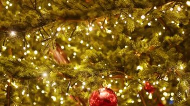 Altın toplar ve ışık çelenkleriyle süslenmiş büyük süslü bir Noel ağacı Avrupa kentinin meydanında duruyor. Açık hava Noel ağacı. Sokak dekorasyonu. Kış tatilinin neşeli gelenekleri.
