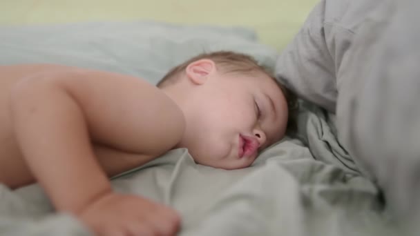 かわいいトッドラーの少年 甘い眠り 午後から小さな子供の睡眠 疲れた赤ん坊は昼寝をする 日常生活や睡眠は幼児にとって非常に重要です 子供のための居心地の良い美しい寝具シート — ストック動画