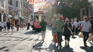 İstanbul, Türkiye - 6 Ağustos 2023: Güneşli yaz gününde İstanbul 'un Beyoğlu ilçesindeki Taksim İstiklal Caddesi' ne bakınız. Red Retro Tramvay, turistler ve yerel turistlerin gözde bir gezisidir.