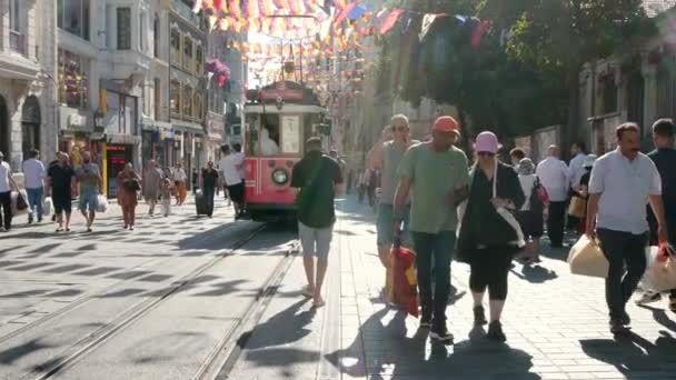土耳其伊斯坦布尔 2023年8月6日 阳光明媚的夏日 伊斯坦布尔碧奥格鲁地区繁忙的塔克西姆Istiklal街 红色复古有轨电车是深受游客和当地游客欢迎的观光景点 — 图库视频影像