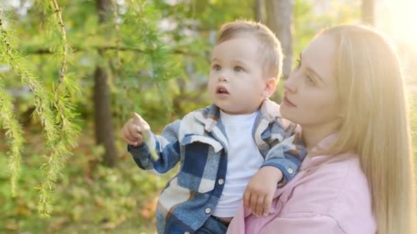 Junge Mutter Und Kleiner Junge Beobachten Eine Schnecke Beim Spaziergang — Stockvideo