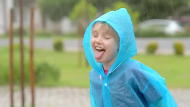 Portret Szczęśliwego Dziecka Ulewnym Deszczu Radosny Chłopiec Niebieskim Płaszczu Przeciwdeszczowym — Wideo stockowe
