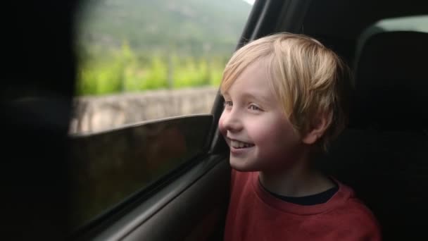 家族旅行中に車の窓から外を眺め 幸せな休暇を楽しみます 子供が休暇中に親と一緒に旅行するのが嬉しいです 田舎を旅する ロイヤリティフリーのストック動画