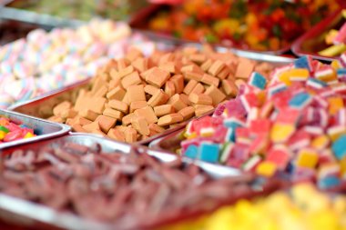 Dükkanda bir sürü renk, jöle, şeker, şekerleme, karamel ve çikolata satılıyor. Yemek arkaplanı olarak çeşitli renkte tatlılar. Renkli doku. Yakın plan..
