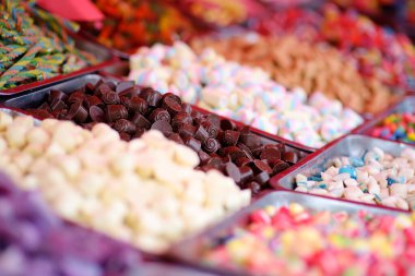 Dükkanda bir sürü renk, jöle, şeker, şekerleme, karamel ve çikolata satılıyor. Yemek arkaplanı olarak çeşitli renkte tatlılar. Renkli doku. Yakın plan..