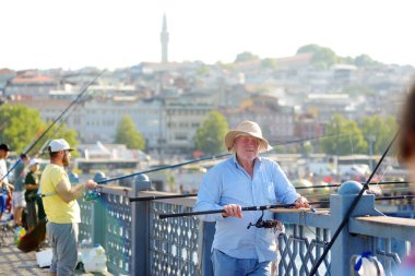 İstanbul, Türkiye - 5 Ağustos 2023: Yeni Cami (Yeni Cami) önündeki ünlü Galata Köprüsü 'nde balıkçılar balık tutuyor.