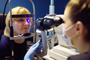 Göz doktoruyla göz muayenesi yapın. Göz kapaklarının, skleranın, konjonktivitenin, lensin, korneanın biyomikroskobik analizi için göz doktoru tarafından ziyaret edilen hasta. Retina ve mantar kontrolü..