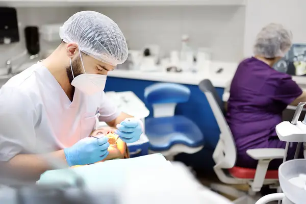 现代医疗中心的牙科医生和病人 医生在医院治疗一位年轻妇女的牙齿 医生在对病人进行正畸或假肢治疗之前对病人进行检查 卫生和牙齿健康 — 图库照片