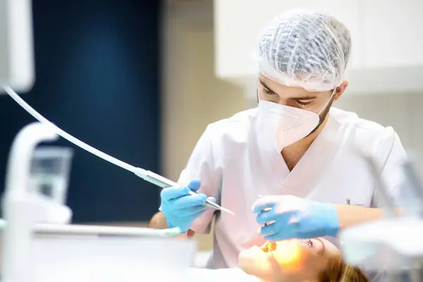 現代医療センターの歯科医と患者さん 医者は病院で若い女性の歯を治療する プラクティショナーは 矯正歯科医または義肢療法の前に患者を診察する 衛生と歯が健康に ストック画像