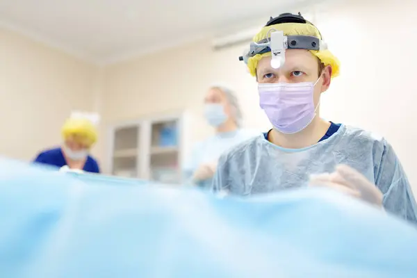 外科医は 現代の病院で顕微鏡と内視鏡を使用してマキシロフェイシャル操作中にいます オペレーティングルームで医師のチームワーク マクシロフェイシャルオペレーション ストック写真