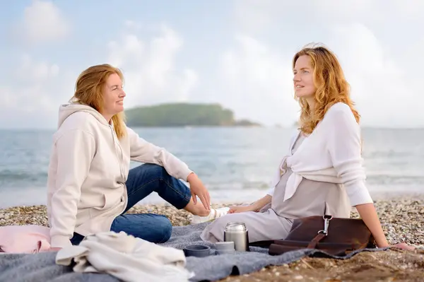 Redhead Senior Mother Her Adult Pregnant Daughter Having Picnic Sea Stock Photo