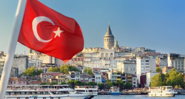 İstanbul, Türkiye - 6 Ağustos 2023: Günbatımında köprüye yakın Golden Horn sahil şeridinin manzarası. Çok uzakta ünlü Galata Kulesi var. Önünde Türk bayrağı bulunan İstanbul 'un güzel, yoğun şehir manzarası
