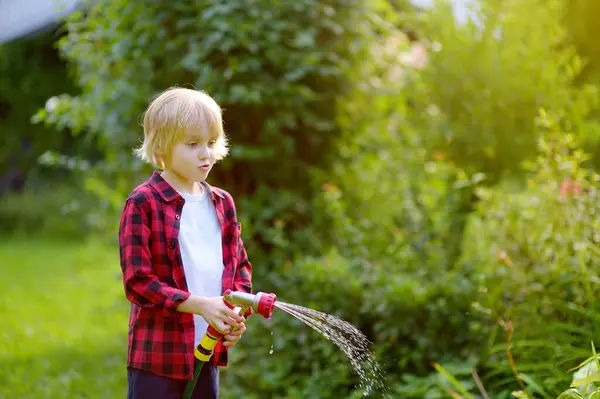 Sød Dreng Vanding Planter Lege Med Haveslange Med Sprinkler Solrig Stock-billede