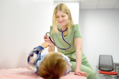 Küçük tatlı bir çocuk ilgili bir çocuk doktoruyla randevuda. Doktor steteskop kullanan küçük bir hastanın kalp atışlarını ve nefes alışlarını dinliyor. Çocuklarda viral ve bakteriyel hastalıklar