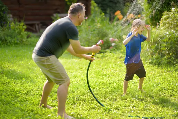 Funny Little Boy His Father Playing Garden Hose Sunny Backyard Immagine Stock
