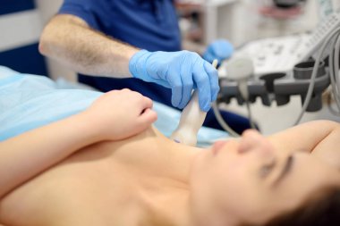 Mammolog doktor ultrason kullanarak göğüs ve lenf düğümlerini muayene ediyor. Mammografi ve ultrason taraması meme bezlerinin ana enstrümantal tanı metodlarıdır. Göğüs kanseri farkındalığı