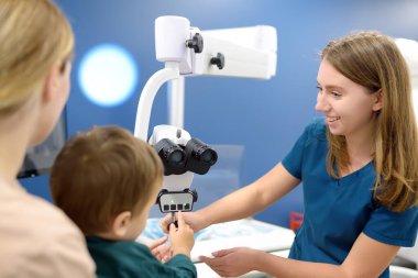 Küçük tatlı bir çocuk annesiyle birlikte anaokuluna hazırlanmak için pediatrik bir KBB ile randevuda. Doktor otolaryngologist küçük hastayla iletişim ve güven kuruyor.