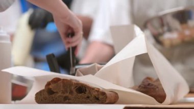 Restoran ya da kafe mutfağının yakın çekim videosu ve müşteriler için yemek hazırlayan işçiler. Yerel bir fırında iş akışı.