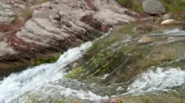 Taşlar arasında akan bir dağ nehrindeki en saf şeffaf su. Dağlarda bulutlu bir gün. Dağ pınarındaki saf temiz su. Bir dağ şelalesinde su akıntısı akıntısını aşar.