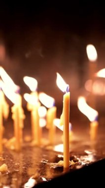 Kilisede yanan bir grup ince mum. Kilise cemaati bir Ortodoks veya Katolik kilisesinde mum yakar. Merhumun dinlenmesi için mumlar yakıldı. Hıristiyan Noel veya Paskalya