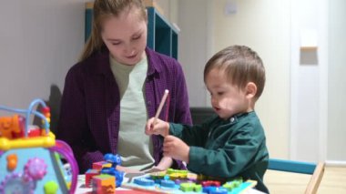 Güzel bir anne, günlük giysiler içinde oğluyla oyun alanında doktor randevusunu beklerken oynuyor. Anaokulu öğretmeninin eğitici oyuncaklarla oynayan sevimli küçük çocukla ilgilenmesi.