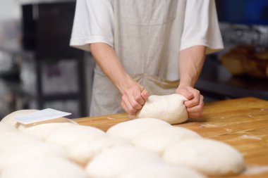 Fırın şefi ekmek pişirmek için hamur hazırlar. Fırıncı hamuru yoğurur ve eski geleneksel tariflere göre eko-ekmek pişirir. Yerel bir fırında iş akışı. Ciabatta yapımı