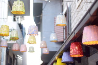 Dekoratif hasır lambaları küçük bir Avrupa kasabasındaki bir restoranın masalarının altındaki büyük bir ağaca asılıydı.,