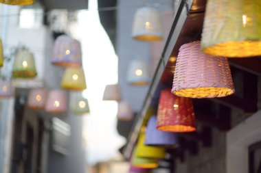 Dekoratif hasır lambaları küçük bir Avrupa kasabasındaki bir restoranın masalarının altındaki büyük bir ağaca asılıydı.,