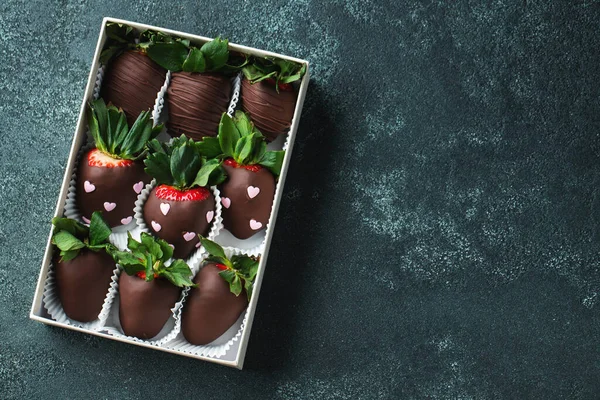 Gourmet chocolate covered strawberries on the dark background. Delicious strawberries in a box for Valentine\'s Day.