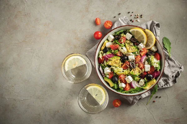 Farklı yaprak ve sebzelerden oluşan lezzetli ve sağlıklı yeşil salata. Koyu beton arka planda tohum ve peynir karışımı. Boşluğun bir kopyasıyla en üstteki görünüm.