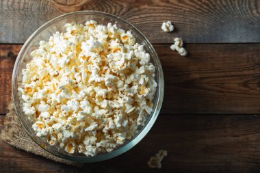 Ahşap arka planda patlamış mısır. Yemek ve atıştırmalık kavramları. En düşük görünüm modeli. Kopyalama alanı olan üst görünüm