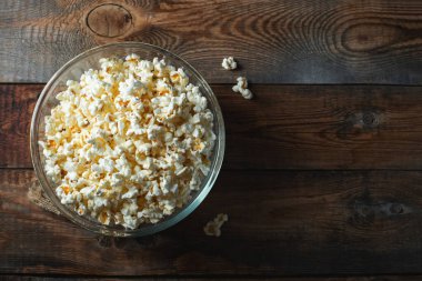 Ahşap arka planda patlamış mısır. Yemek ve atıştırmalık kavramları. En düşük görünüm modeli. Kopyalama alanı olan üst görünüm