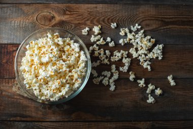 Ahşap arka planda patlamış mısır. Yemek ve atıştırmalık kavramları. En düşük görünüm modeli. Kopyalama alanı olan üst görünüm