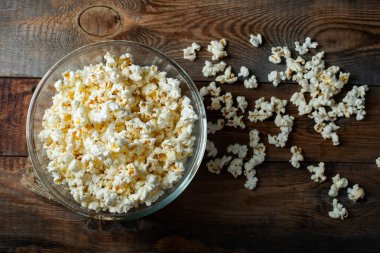 Ahşap arka planda patlamış mısır. Yemek ve atıştırmalık kavramları. En düşük görünüm modeli. Kopyalama alanı olan üst görünüm