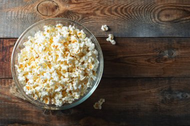 Ahşap arka planda patlamış mısır. Yemek ve atıştırmalık kavramları. En düşük görünüm modeli. Kopyalama alanı olan üst görünüm