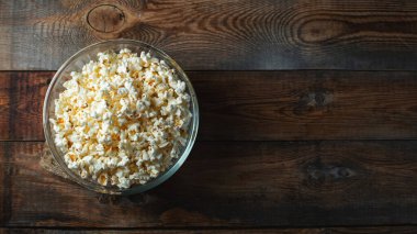 Ahşap arka planda patlamış mısır. Yemek ve atıştırmalık kavramları. En düşük görünüm modeli. Kopyalama alanı olan üst görünüm