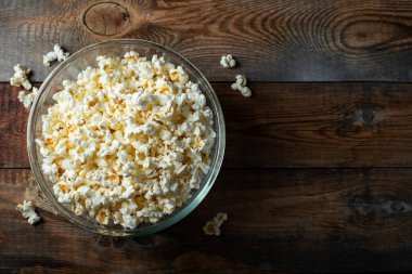 Ahşap arka planda patlamış mısır. Yemek ve atıştırmalık kavramları. En düşük görünüm modeli. Kopyalama alanı olan üst görünüm