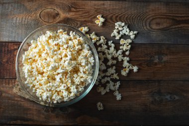 Ahşap arka planda patlamış mısır. Yemek ve atıştırmalık kavramları. En düşük görünüm modeli. Kopyalama alanı olan üst görünüm