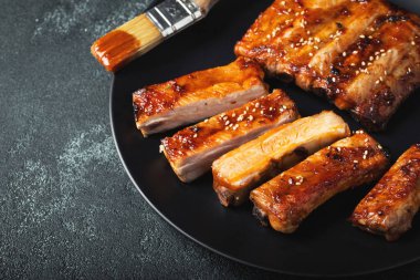 Barbekü soslu bir tabakta servis edilen sıcak ızgara pirzola. Üst Manzara. Boşluğu kopyala.