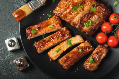 Barbekü soslu bir tabakta servis edilen sıcak ızgara pirzola. Üst Manzara. Boşluğu kopyala.