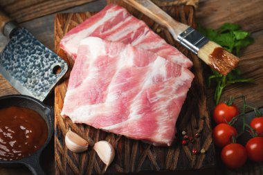 Çiğ Domuz kaburga ile baharat, tuz ve koyu ahşap zemin üzerine biberiye.