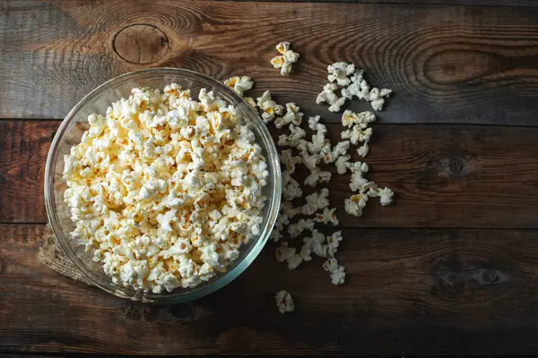 Ahşap arka planda patlamış mısır. Yemek ve atıştırmalık kavramları. En düşük görünüm modeli. Kopyalama alanı olan üst görünüm