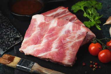 Çiğ et. Sırtından çiğ domuz kaburgası ve siyah bir arka planda et. arkaplan resmi, boşluk metni kopyala