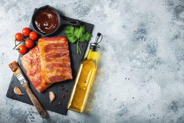 Barbekü, çiğ domuz pirzolası ve barbekü sosu hazır. Siyah arka plan. Üst görünüm.